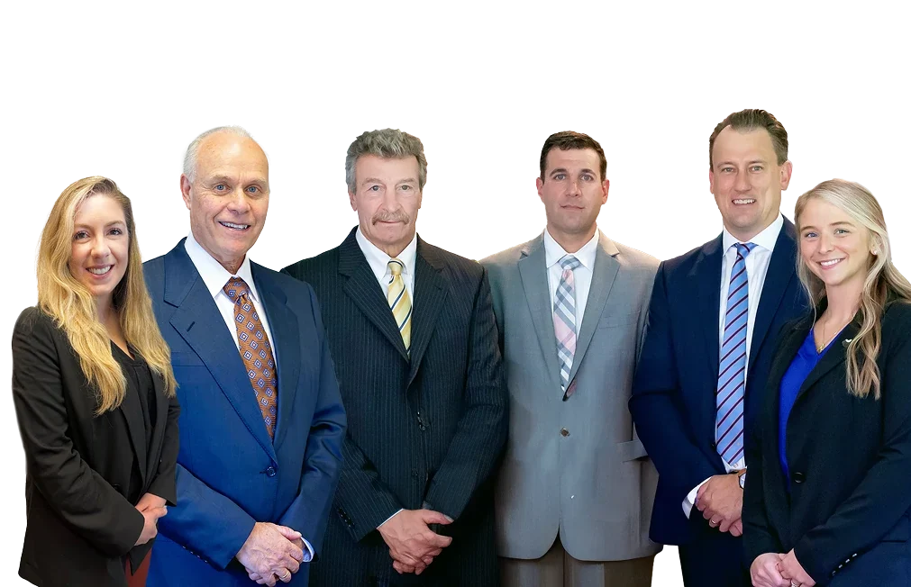 A group of six professionally dressed individuals stands together against a black background, showcasing a range of suits and hairstyles